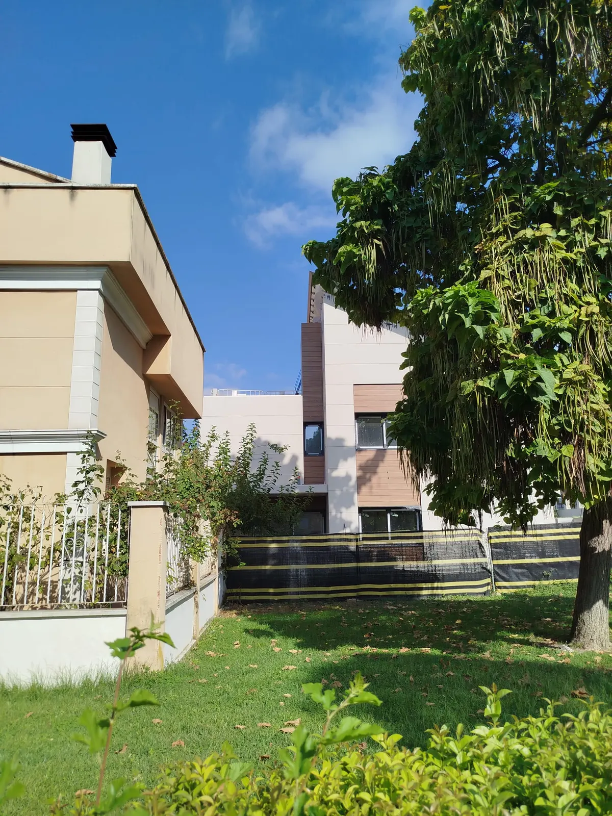 Vista lateral del chalet con jardín y carpinterías nuevas